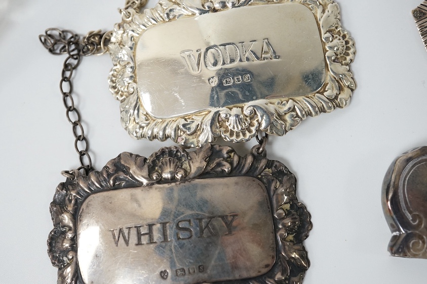 A small group of collectable silver including a Victorian engraved card case, Hilliard & Thomason, Birmingham, 1856, 10cm, three modern wine labels, a vesta case, a 925 pill box and an Edwardian mounted glass scent bottl